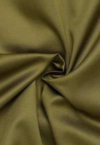Tessuto di raso verde oliva, texture liscia e lucentezza morbida, drappeggiato e attorcigliato, che mostra la sua fluidità e l'aspetto lussuoso.