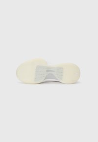 Semelle de chaussure avec une bande de roulement en caoutchouc blanc, présentant un motif texturé et une section centrale lisse. Semelle intermédiaire en gris clair, contrastant avec la semelle.