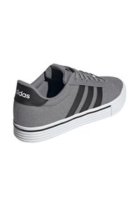 Gray canvas sneaker with black stripes and branding, white rubber sole, low-top design, rounded toe, and tonal stitching details.