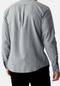Camicia a maniche lunghe da uomo color grigio chiaro con un motivo a quadri testurizzato, dotata di piega sul retro, polsini con bottone e orlo curvo.