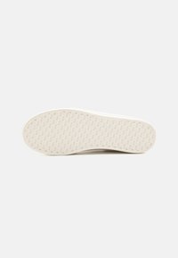 Semelle en caoutchouc blanche avec un motif géométrique texturé, des bords arrondis et un design épuré et minimaliste. Fini lisse sans marquages visibles.