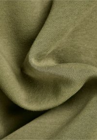 Tessuto di cotone verde oliva, testurizzato, drappeggiato per mostrare una superficie liscia e una consistenza morbida, con una leggera elasticità e un motivo a maglia fine.