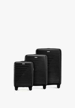 Tres maletas rígidas negras de diferentes tamaños. Tienen una textura rayada, cuatro ruedas y asas superiores para una fácil maniobrabilidad.
