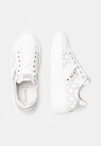 Białe sneakersy o gładkim skórzanym wykończeniu, z tłoczonym wzorem logo, srebrnymi akcentami i płaskimi białymi gumowymi podeszwami. Zaciągane na sznurowadła.