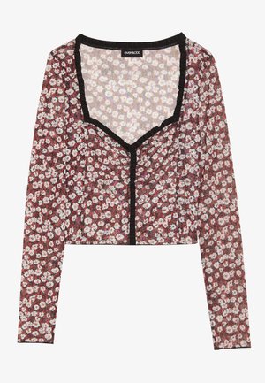 Floral crop top with long sleeves. Red base, white and pink flower print, black ruffled trim at neckline and front opening, lightweight fabric.