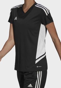 Černá sportovní dres s krátkými rukávy, V-výstřihem, bílým bočním panelem a třemi bílými pruhy na ramenou. Vyrobeno z lehké tkaniny.