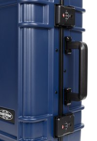 Laavapintainen, navy sininen kova matkalaukku, jossa on mustat metalliosat, kaksi yhdistelmälukkoa ja sivukahva helppoa kantamista varten.