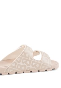 Sandale à glissière beige avec des brides à motif géométrique et une semelle texturée, conçue pour un usage décontracté.