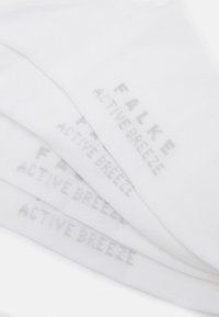 Hvite sokker laget av et mykt stoff, med trykt tekst "FALKE ACTIVE BREEZE" i lys grå, med en jevn tekstur og enkelt design.
