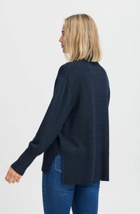 Navy-blauer Pullover mit gerippten Bündchen und Saum, in lässiger Passform und seitlichen Schlitzen, aus einem weichen, strukturierten Material gefertigt.
