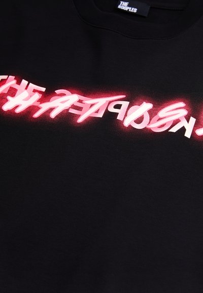 Black sweatshirt featuring bold, stylized text in pink and white, with a gradient effect. Fabric appears soft and smooth.