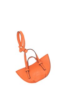 Small orange leather handbag with a rounded shape, dual handles, and visible stitching detail. Smooth texture and contrast stitching accents.