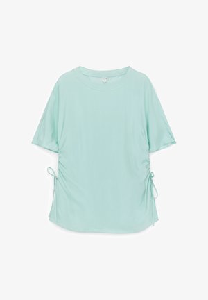 Lichtblauw overhemd met korte mouwen, ronde hals en zijdetails met trekkoord op een witte achtergrond.