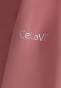 Rosa vattentåligt tyg med den silverfärgade logotypen "Celavi"® i nedre högra hörnet, med en slät textur och matt finish.