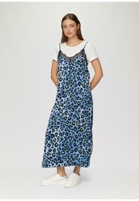 Blauwe luipaardprint jurk met kant banden, voorzien van zwarte kantafwerking en een losse pasvorm. Draag over een wit T-shirt, gecombineerd met witte sneakers.