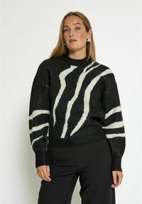 Gestreifter Strickpullover in Schwarz und Weiß mit hohem Kragen, lockeren Ärmeln und geripptem Saum, aus weichem Material und mit kräftigem Muster.