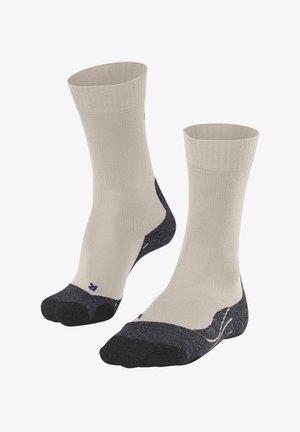 Calzini beige alla caviglia con sezioni di tallone e punta in grigio scuro. Texture liscia con punta rinforzata e dettaglio logo sottile.