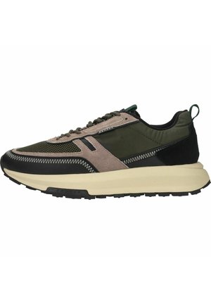 Sneaker basse avec mesh vert, surpiqûres en daim beige, accents noirs, semelle épaisse crème et languette latérale, vue de l’extérieur.
