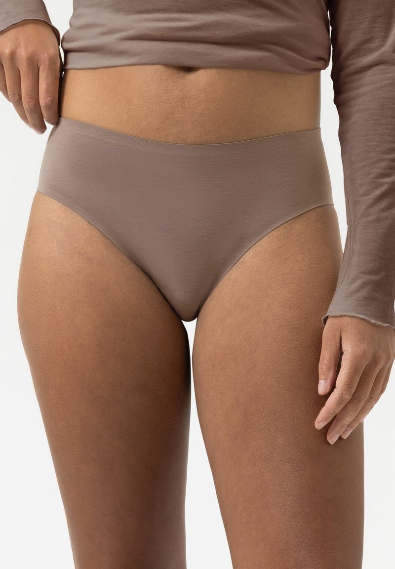 Mutande a vita alta seamless di colore marrone indossate da una persona con un top a maniche lunghe marrone abbinato, mostrate dalla vita alle cosce su uno sfondo bianco.