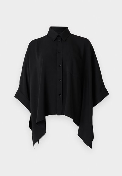 Chemise noire à boutons avec col châle, manches courtes et silhouette carrée. Confectionnée dans un tissu lisse, avec une poche poitrine.