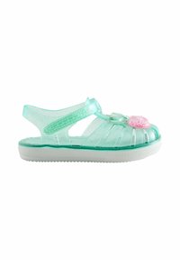 Sandale pour enfants vert menthe transparent avec bride ajustable et décoration en forme de cœur rose, sur une semelle blanche.