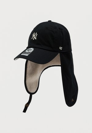 Melnā cepure ar izliekto malu, kurai ir balti izšūts 'NY' logotips. Uz ausu aizsargiem ir flīsa oderējums, regulējama zoda josta un strukturēta auduma apdare.