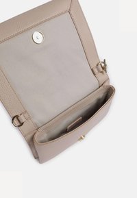 Borsa in pelle beige con esterno texturizzato e interno liscio. Presenta una chiusura a scatto dorata e un unico scomparto per lo stoccaggio.
