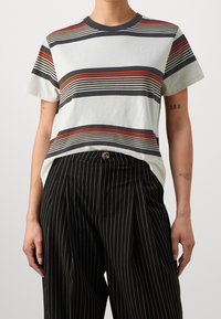 Stribet kortærmet t-shirt i lys grøn, med vandrette linjer i rød, sort og elfenben. Fremstillet af bomuldsmateriale, afslappet pasform.
