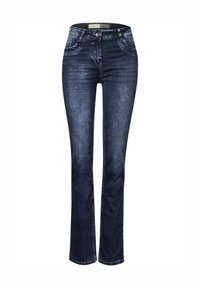 Tummansiniset farkut, joissa on suora lahje, etutaskut, vetoketjukiinnitys ja hillityt ompeluyksityiskohdat.