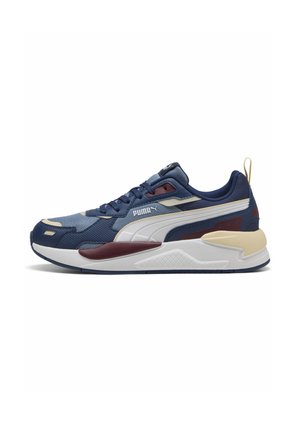 Blue and navy athletic shoe with white accents, textured upper, reinforced toe, and contrasting maroon and cream details. Lace-up design.