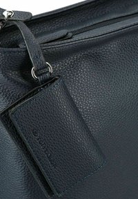 Bolso de cuero azul oscuro con una superficie texturizada y un tarjetero a juego, que cuenta con herrajes plateados y detalles de costura en azul.