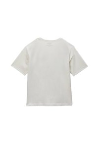 T-shirt en coton blanc à manches courtes, encolure ronde et texture lisse. Le dos présente des coutures invisibles et des détails de label imprimés.