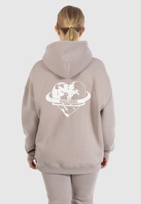 Lichtgrijze hoodie met een witte grafische afbeelding van een hart en een wereldkaart. Het heeft een kangoeroezak en ribgebreide boorden. Gemaakt van katoen.
