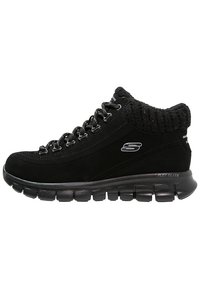 Černé středně vysoké tenisky Skechers s polstrovaným pleteným límcem, šněrováním, polstrovanou podrážkou a flexibilní segmentovanou podrážkou.