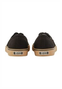 Sneakers neri in tela con suola in gomma beige e dettaglio logo sul tallone. Lacci piatti e silhouette bassa. Fianchi texturizzati.
