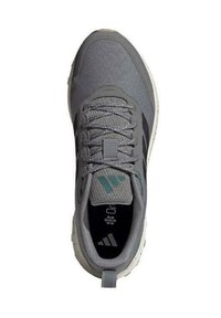 Zapatilla deportiva gris con parte superior texturizada, cordones circulares y acentos verdes. Cuenta con una suela acolchada y una lengüeta trasera para facilitara la puesta.
