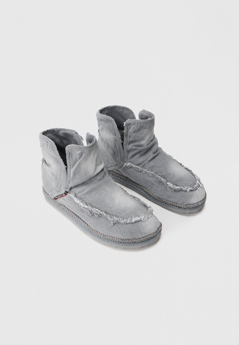 Botas de tobillo grises hechas de una tela texturizada con bordes deshilachados. Presentan un diseño fácil de poner, suela trenzada y detalles de costura visibles.