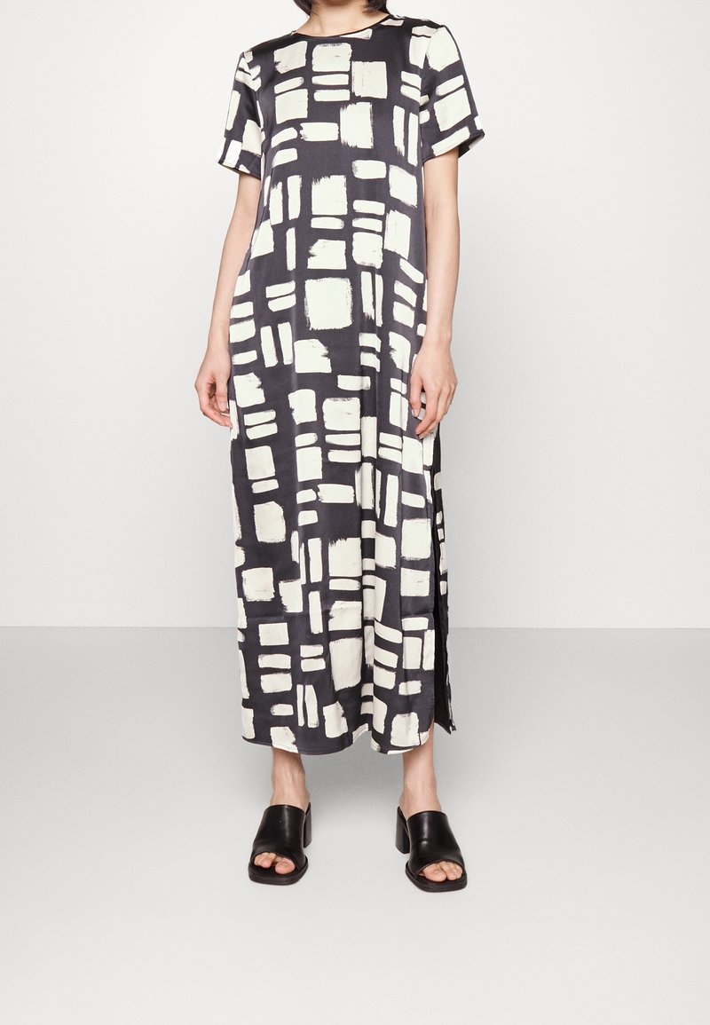 Vestido maxi de estampado en blanco y negro con mangas cortas, que presenta diseños de trazos de pincel rectangulares y aberturas laterales para facilitar el movimiento.
