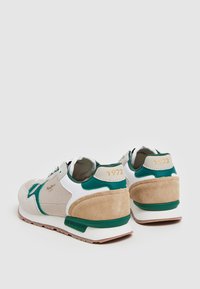 Sneakers con una combinazione di rete beige, pelle bianca e dettagli verdi. Presentano un contrafforte in suede e la scritta dorata "1973".