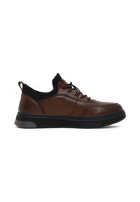 Baskets en cuir marron avec un bout rond, semelle en caoutchouc noir texturé, col en tissu noir et lacets noirs. Présente des détails de couture minimalistes.
