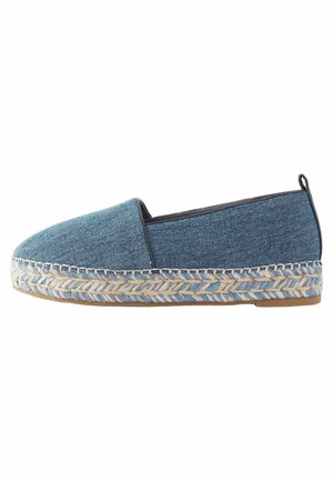 Denim slip-on shoe with a rounded toe, woven jute sole, and contrasting stitching. Features a textured blue fabric and a low profile design.