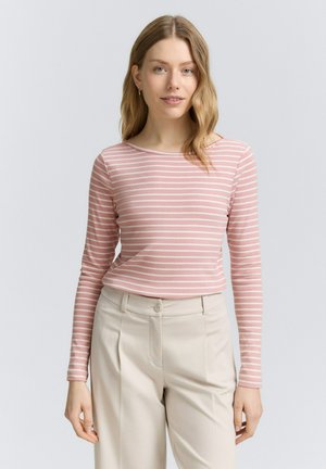 Långärmad, ljusrosa randig topp gjord av mjukt tyg. Den har en rund halsringning och matchas med beige byxor.