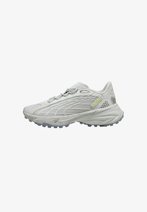 Graue Sportschuhe mit einem Obermaterial aus Mesh, strukturiertem Muster und einer Gummisohle mit auffälligen Traktionsnoppen; minimalistische Markenakzente.