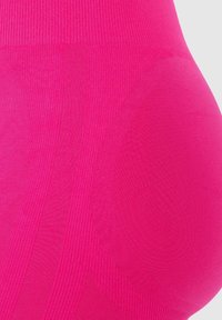 Felroze legging gemaakt van rekbaar materiaal, met een geribde tailleband en gestructureerde accenten in een soepele, aansluitende stijl.