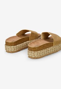 Sandales compensées en daim tan avec des semelles en jute tressé, présentant une large bride au niveau des orteils et un coussin de pied ergonomique.