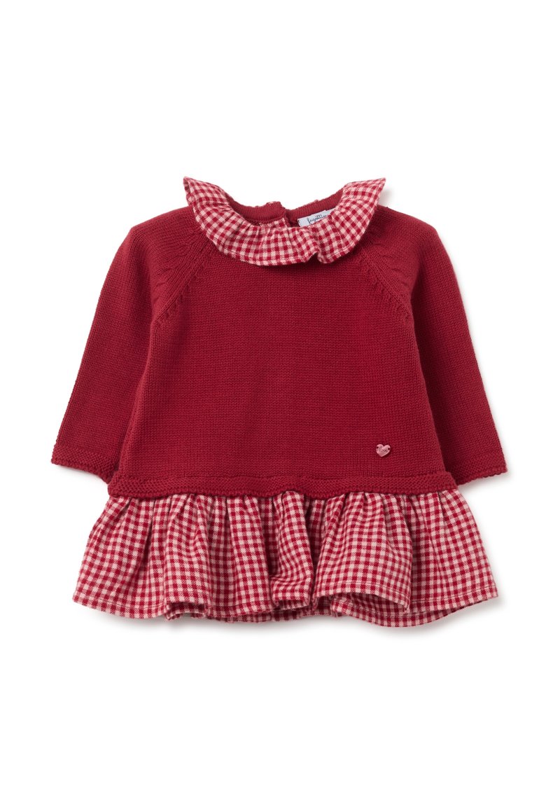 Robe tricotée rouge avec jupe à volants en vichy, avec un col évasé et un petit accent en forme de cœur. Manches longues, corsage texturé avec des détails de coutures.