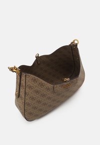 Ruskea kuviollinen kassi, jossa on teksturoitu pinta, kultaiset metalliosat ja avoin yläosa. Brändin logo näkyy etuosassa.