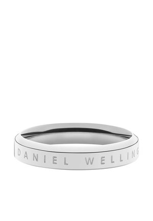 Sølvring i metal med indgraveret navnet "DANIEL WELLINGTON" på ydersiden, vist mod en hvid baggrund.