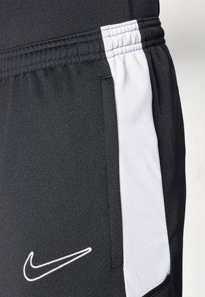Black athletic shorts featuring a white side panel, elastic waistband, and the Nike swoosh logo in white stitching on the front.