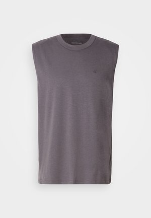 Bezdantė pilka marškinėlių su apvalia iškirpte, pagaminti iš minkštos medvilnės mišinio, su subtiliu logotipu ant krūtinės. Lygi tekstūra, laisvas kirpimas.